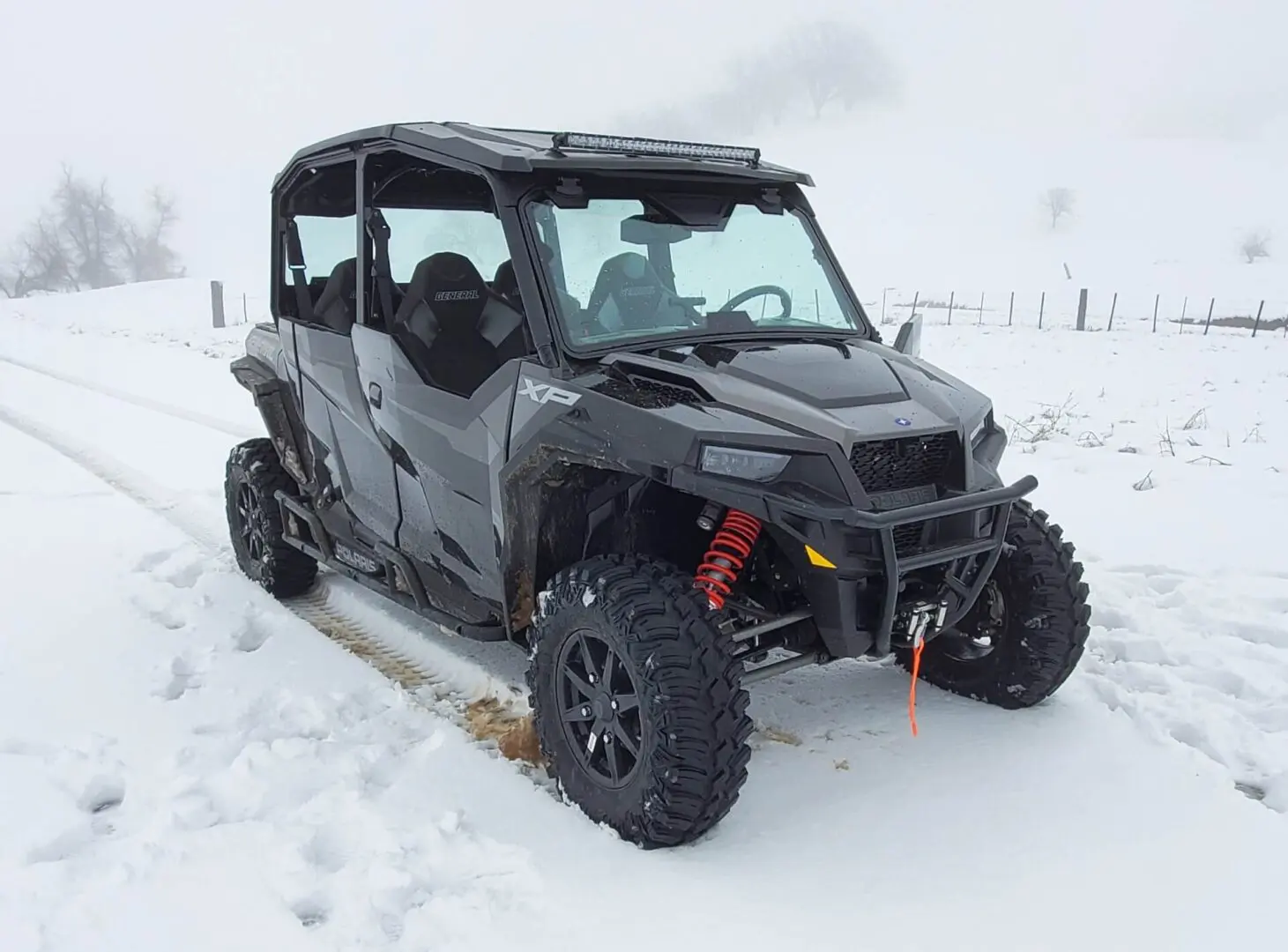 A black four wheeler parked in the snow.